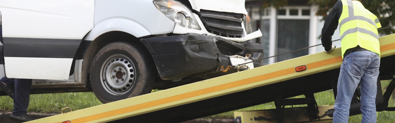 Ein beschädigter Transporter wird auf ein Abschleppfahrzeug verladen